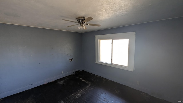 unfurnished room with ceiling fan and a textured ceiling