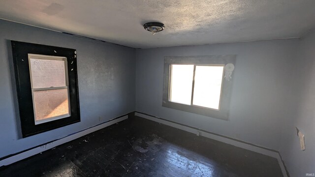 unfurnished room featuring a textured ceiling