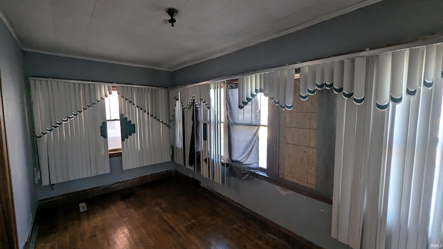 spare room featuring dark hardwood / wood-style flooring and crown molding