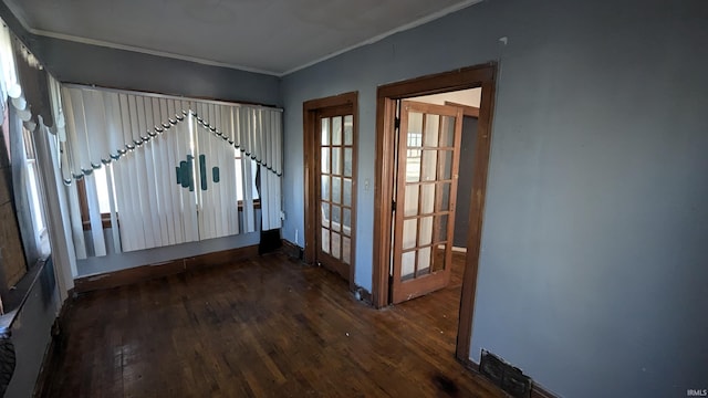 interior space featuring dark hardwood / wood-style flooring, ornamental molding, and french doors