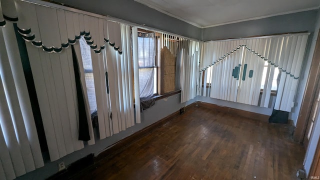 unfurnished room featuring plenty of natural light, dark wood-type flooring, and ornamental molding