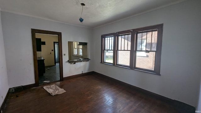 interior space featuring dark wood-type flooring, a textured ceiling, and ornamental molding