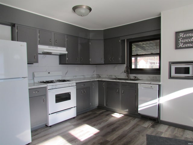 kitchen with dark hardwood / wood-style flooring, gray cabinetry, sink, and white appliances