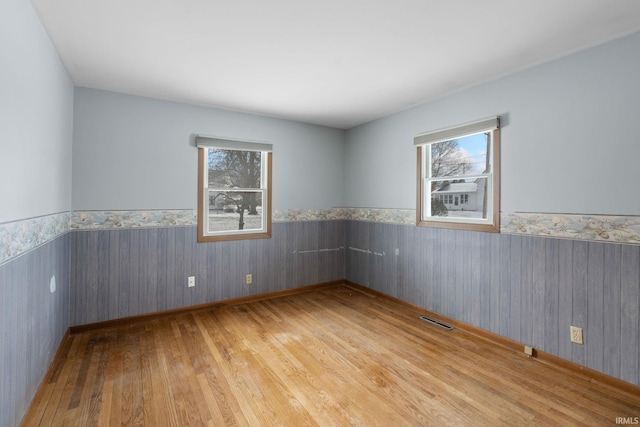 spare room featuring light hardwood / wood-style flooring and a healthy amount of sunlight