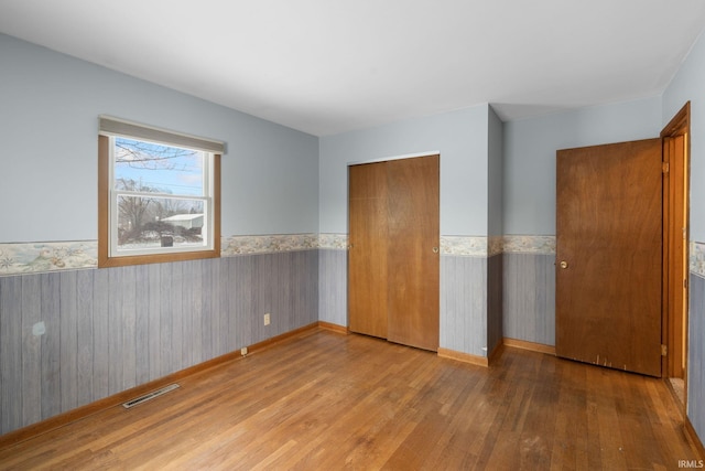 unfurnished bedroom featuring light wood-type flooring and a closet