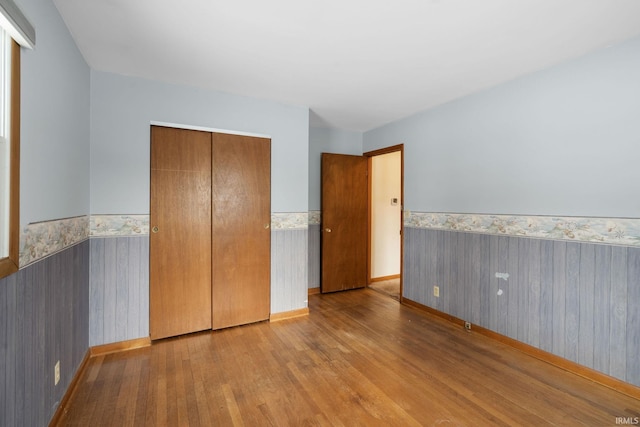 unfurnished bedroom with light hardwood / wood-style floors and a closet