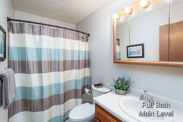 bathroom with vanity, curtained shower, toilet, and a textured ceiling