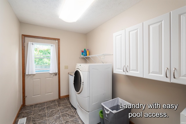 laundry room with cabinets and a textured ceiling