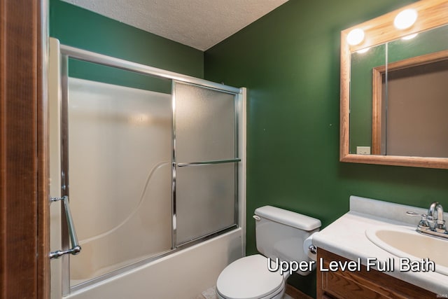 full bathroom featuring toilet, vanity, a textured ceiling, and combined bath / shower with glass door