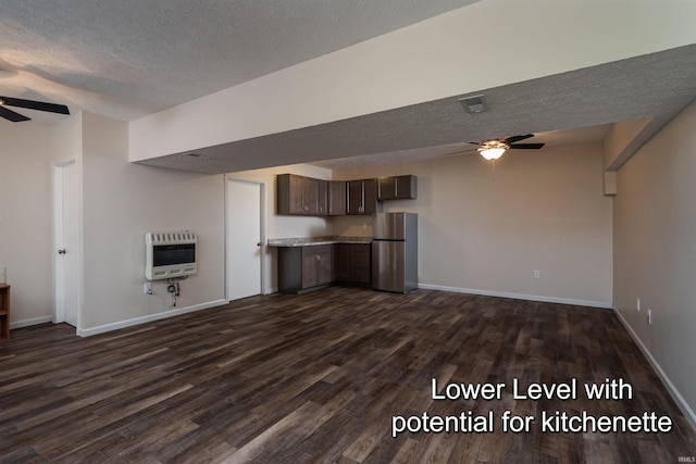 unfurnished living room featuring a textured ceiling, dark hardwood / wood-style flooring, heating unit, and ceiling fan