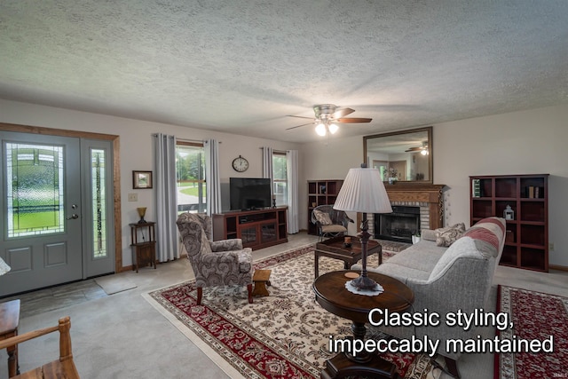 living room with ceiling fan, a fireplace, light carpet, and a textured ceiling