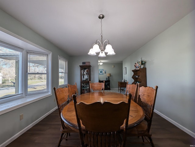 dining space featuring plenty of natural light, dark hardwood / wood-style flooring, and an inviting chandelier