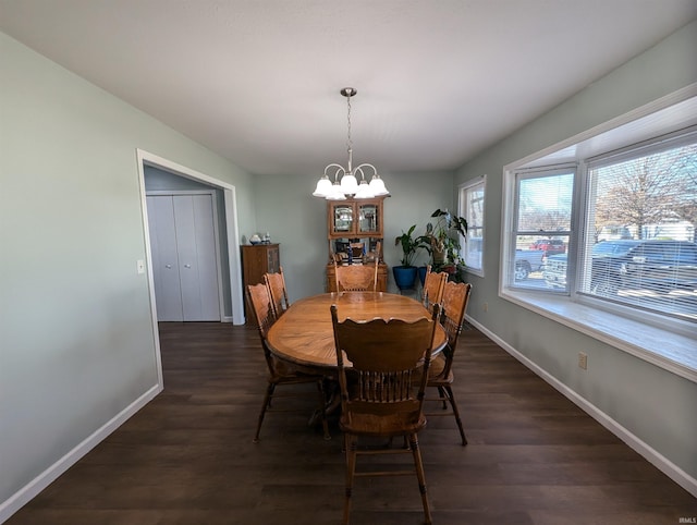 dining area featuring dark hardwood / wood-style flooring and an inviting chandelier