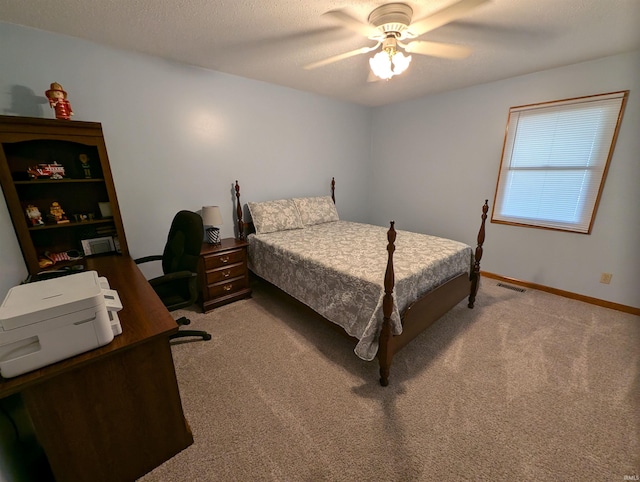 carpeted bedroom featuring a textured ceiling and ceiling fan