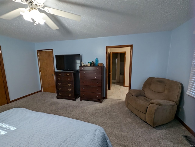 bedroom featuring a textured ceiling, light colored carpet, and ceiling fan