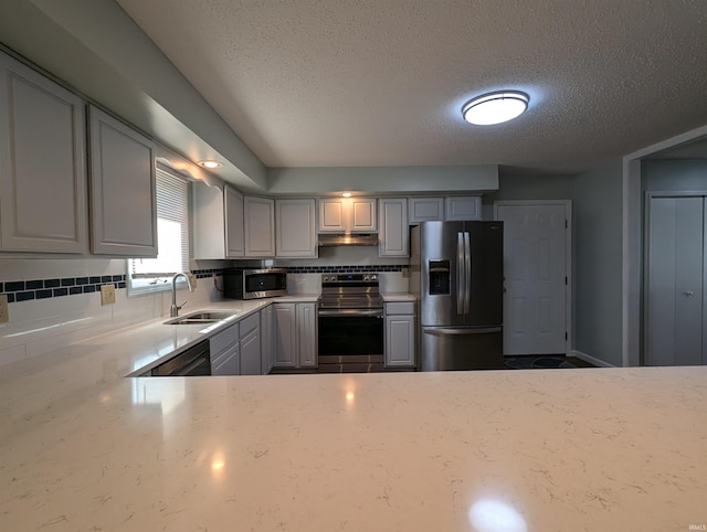 kitchen featuring backsplash, stainless steel appliances, gray cabinets, and sink