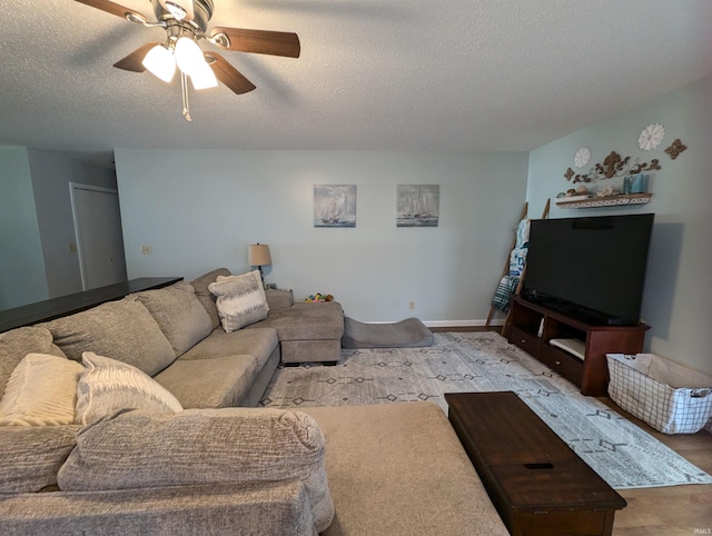 living room featuring a textured ceiling, light colored carpet, and ceiling fan