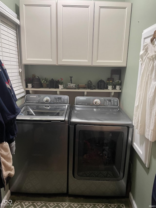 clothes washing area featuring cabinets and independent washer and dryer