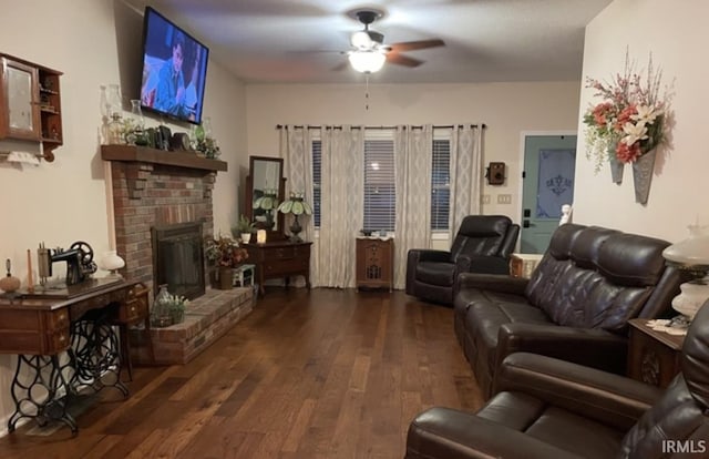 living room with a fireplace, ceiling fan, and dark wood-type flooring