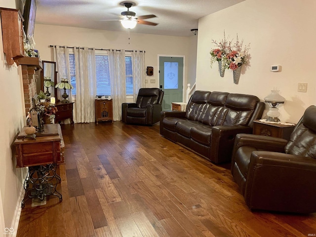 living room with ceiling fan and dark hardwood / wood-style flooring