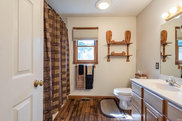 bathroom featuring vanity, wood-type flooring, a textured ceiling, and toilet