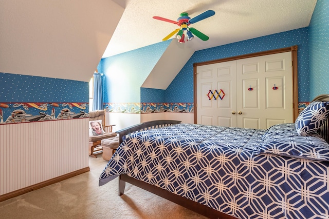 bedroom with light carpet, a textured ceiling, vaulted ceiling, ceiling fan, and a closet