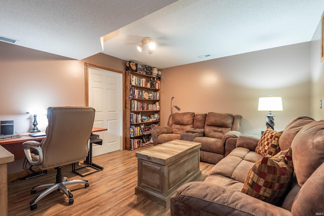 office area featuring a textured ceiling and light hardwood / wood-style floors