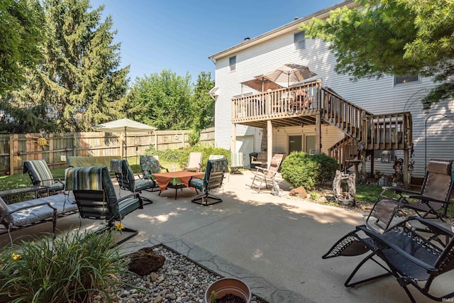 rear view of property with a wooden deck and a patio