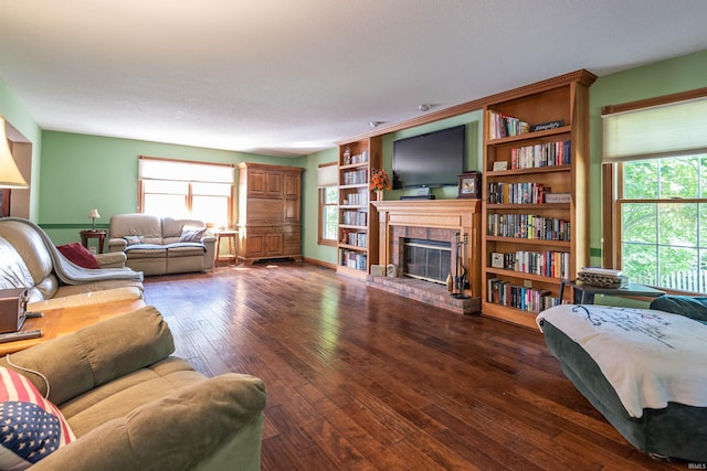 living room with dark hardwood / wood-style floors, a textured ceiling, and a brick fireplace