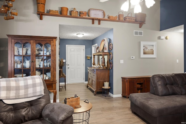 living room featuring light hardwood / wood-style flooring and a textured ceiling