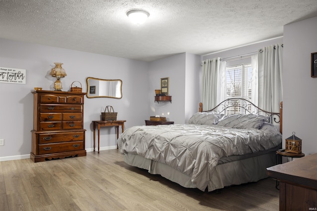 bedroom featuring light hardwood / wood-style flooring and a textured ceiling