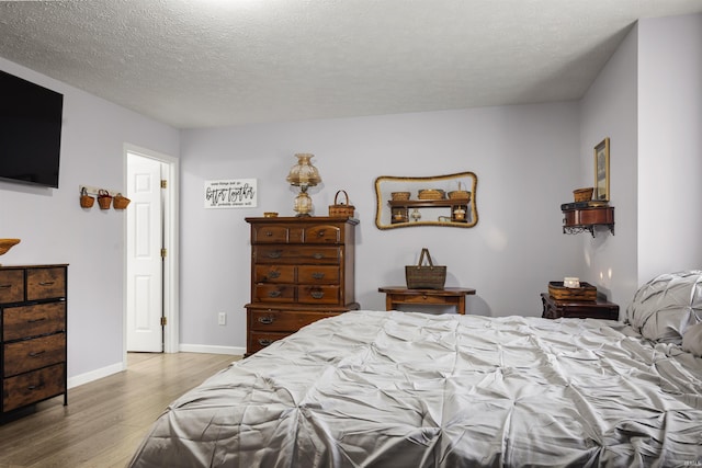 bedroom featuring a textured ceiling and light hardwood / wood-style floors