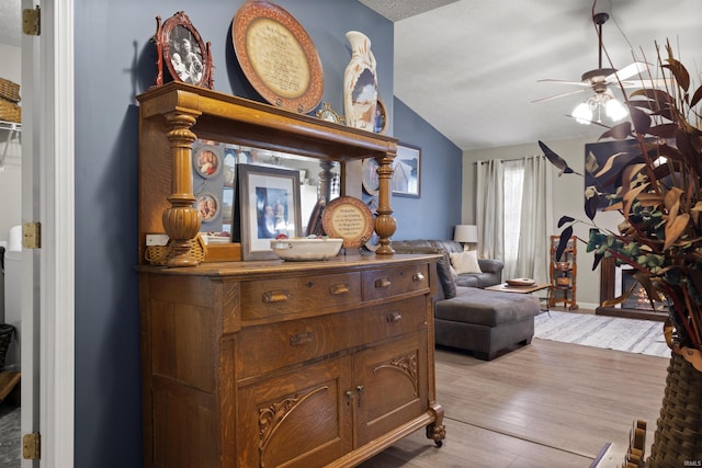 sitting room featuring a textured ceiling, ceiling fan, light hardwood / wood-style flooring, and lofted ceiling