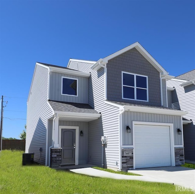 view of front facade with a front yard, a garage, and central AC unit