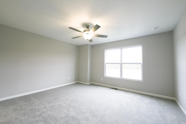 carpeted empty room featuring a textured ceiling and ceiling fan