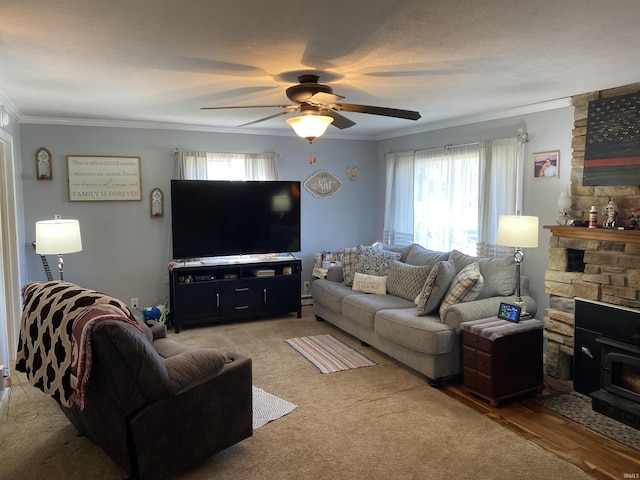 living room featuring a wood stove, ceiling fan, light hardwood / wood-style floors, and ornamental molding