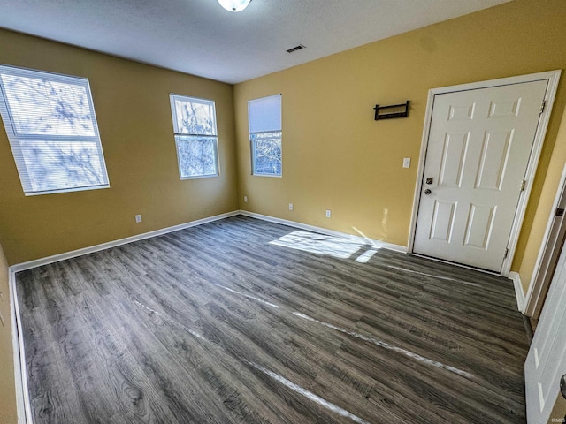 interior space featuring dark wood-type flooring and a textured ceiling