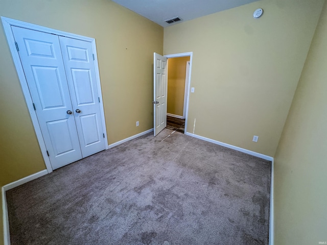 unfurnished bedroom featuring light carpet and a closet