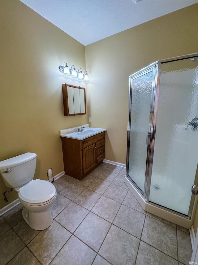 bathroom featuring tile patterned floors, vanity, toilet, and walk in shower