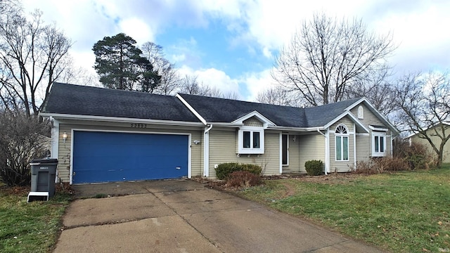 ranch-style house featuring a garage and a front lawn