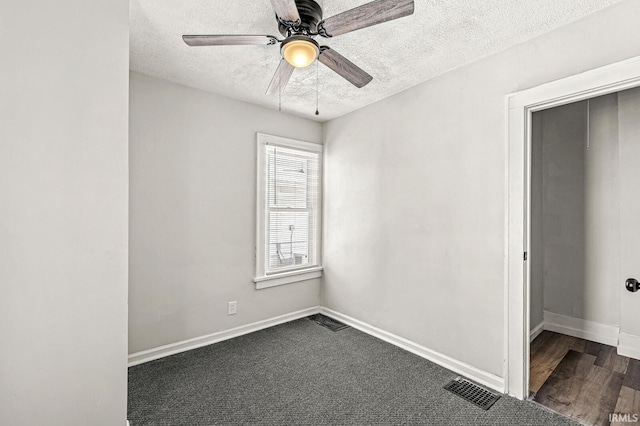 carpeted spare room featuring ceiling fan and a textured ceiling