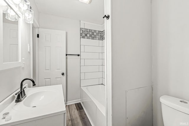 full bathroom with hardwood / wood-style floors, vanity, toilet, and shower / bathtub combination