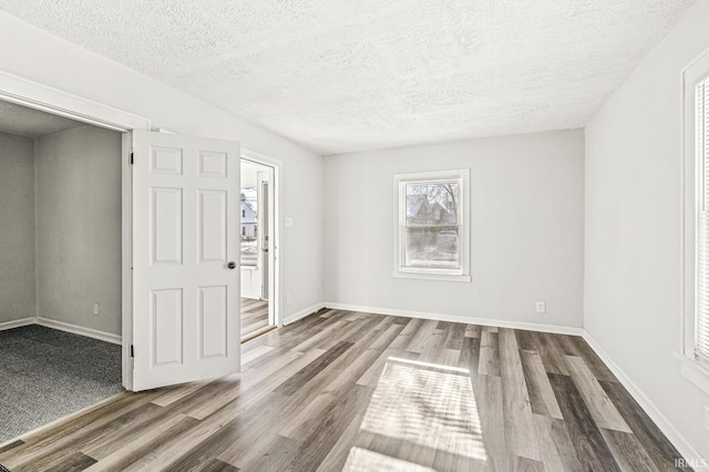 spare room featuring a textured ceiling and hardwood / wood-style flooring