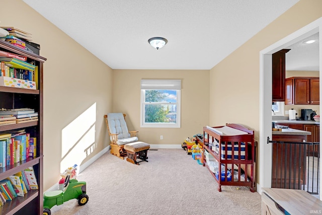 rec room with light colored carpet and a textured ceiling