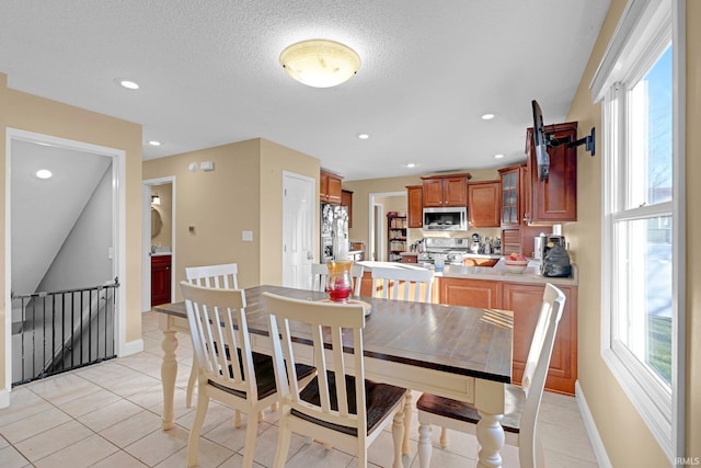 dining space featuring light tile patterned floors and a textured ceiling