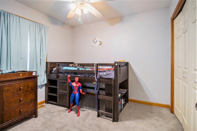 bedroom featuring ceiling fan, light colored carpet, and a closet