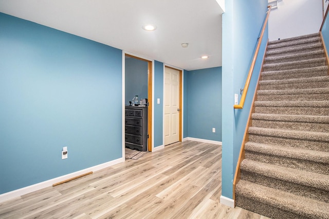 staircase with hardwood / wood-style floors