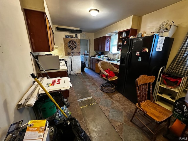 kitchen featuring black fridge with ice dispenser and sink