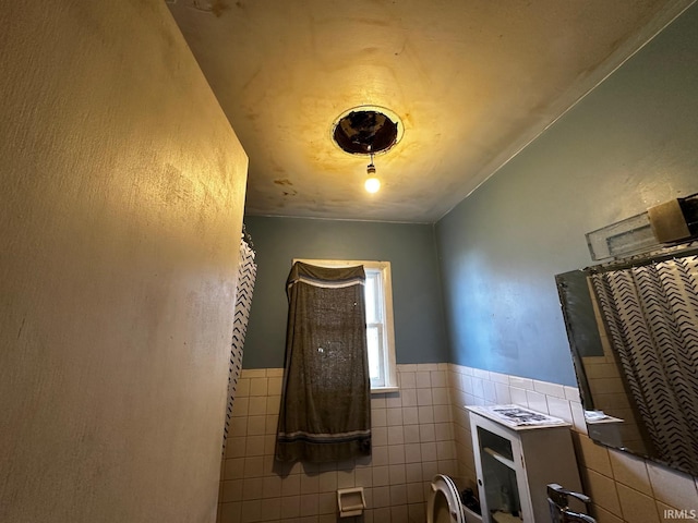 bathroom featuring a shower with shower curtain and tile walls