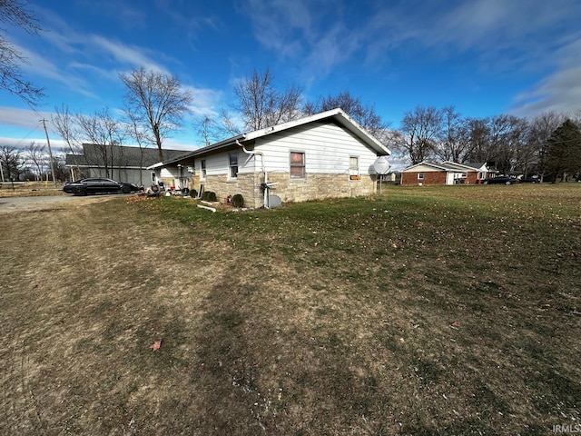 view of side of home featuring a trampoline and a yard